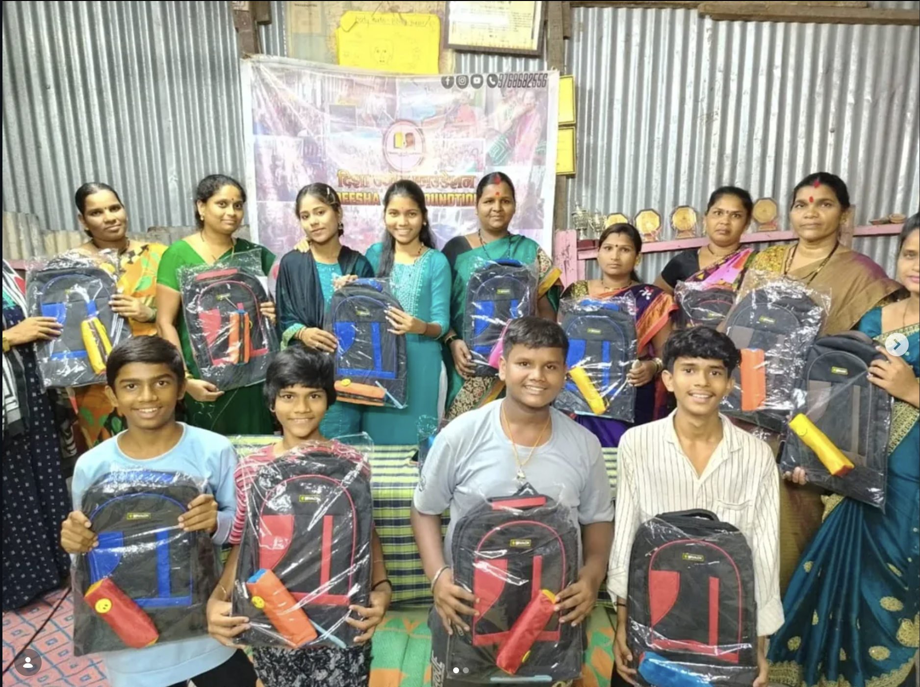 Children and women receiving school kits in a community drive